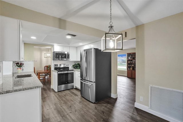 kitchen featuring stainless steel appliances, hardwood / wood-style flooring, decorative light fixtures, and white cabinets