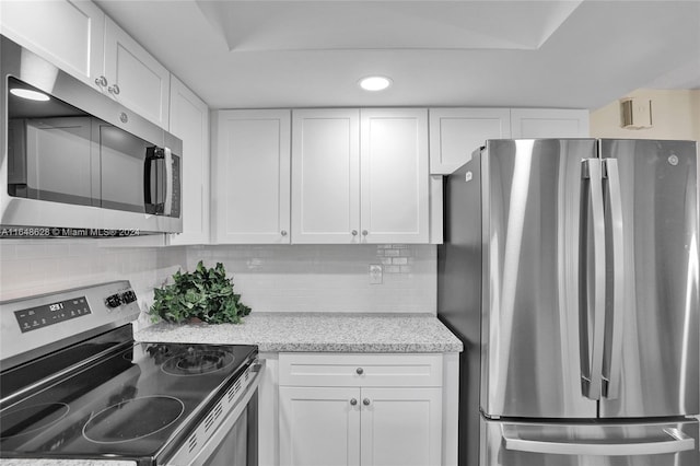 kitchen featuring white cabinetry, stainless steel appliances, and tasteful backsplash