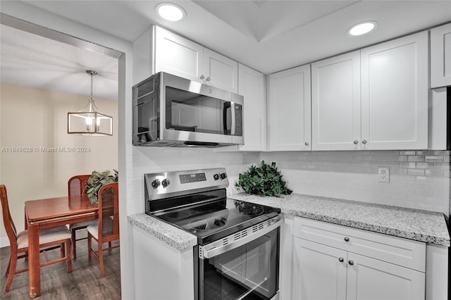 kitchen with dark wood-type flooring, appliances with stainless steel finishes, and white cabinets