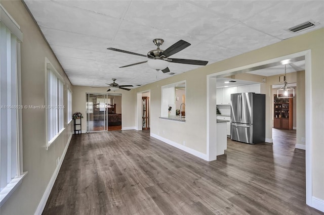 unfurnished living room with dark wood-type flooring, ceiling fan, and sink