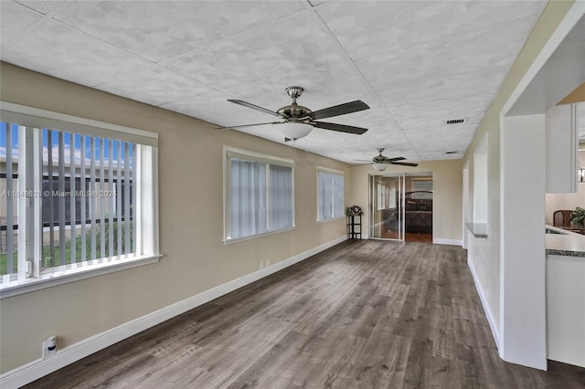 unfurnished living room with ceiling fan and dark hardwood / wood-style floors