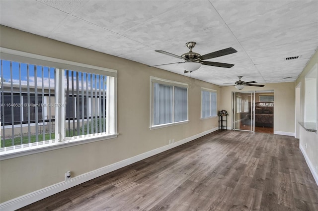 empty room with hardwood / wood-style floors and ceiling fan