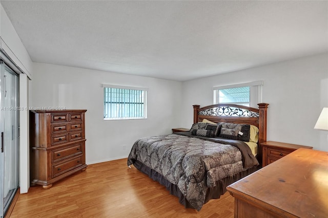 bedroom featuring a textured ceiling, hardwood / wood-style floors, and multiple windows