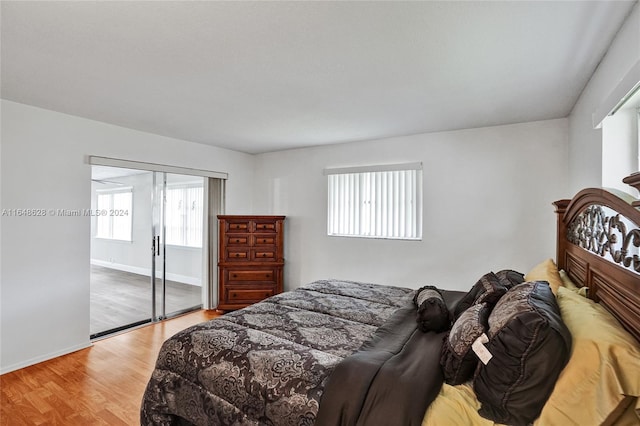 bedroom with multiple windows, wood-type flooring, and a closet