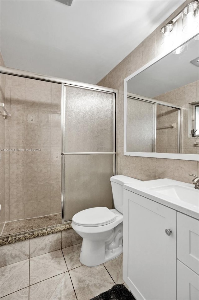 bathroom featuring vanity, an enclosed shower, tile walls, toilet, and tile patterned floors