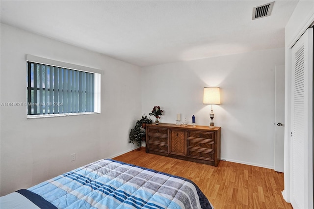 bedroom with a closet and light hardwood / wood-style flooring