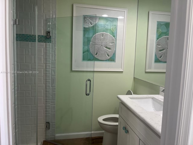 bathroom with walk in shower, toilet, and vanity