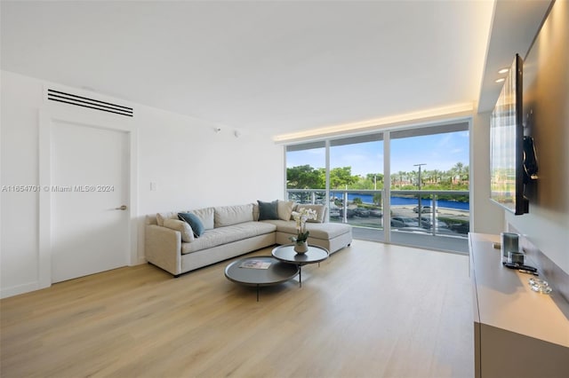 living room featuring light wood-type flooring and expansive windows