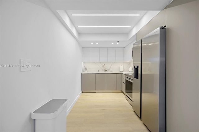 20505 E Country Club Dr Unit 231, Aventura, FL 33180 - kitchen with a sink, decorative backsplash, light countertops, light wood-style floors, and appliances with stainless steel finishes