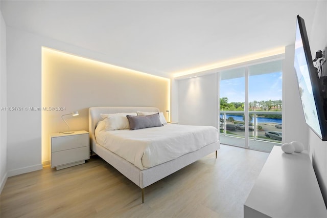 20505 E Country Club Dr Unit 231, Aventura, FL 33180 - bedroom with access to exterior, floor to ceiling windows, light wood-style flooring, and baseboards