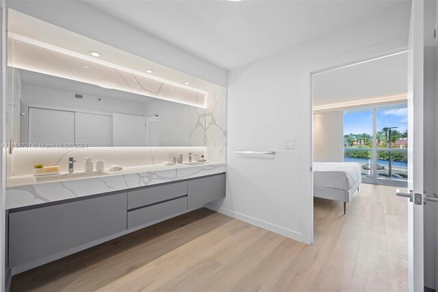 20505 E Country Club Dr Unit 231, Aventura, FL 33180 - ensuite bathroom featuring double vanity, baseboards, ensuite bath, and wood finished floors