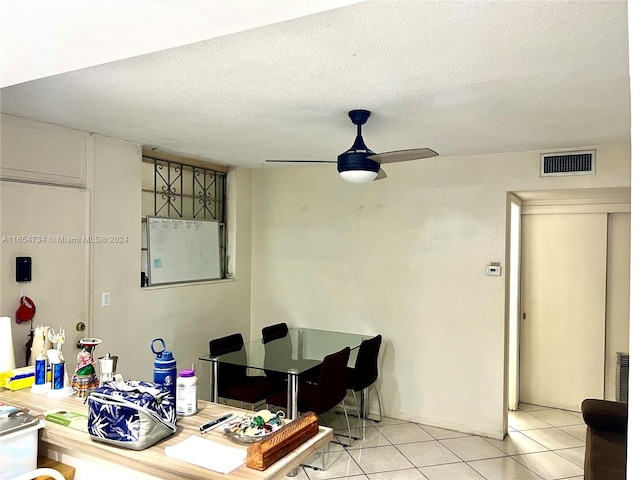 dining area with a textured ceiling, light tile patterned flooring, and ceiling fan