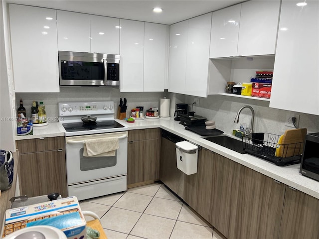 kitchen featuring white cabinets, backsplash, light tile patterned floors, and stainless steel appliances