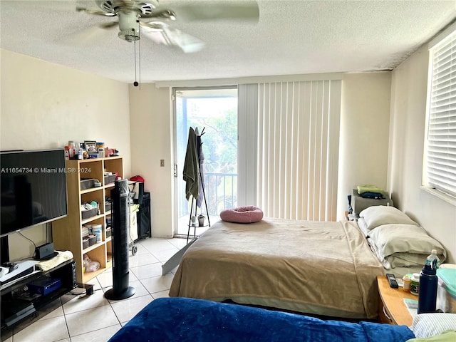 tiled bedroom with ceiling fan, access to outside, and a textured ceiling