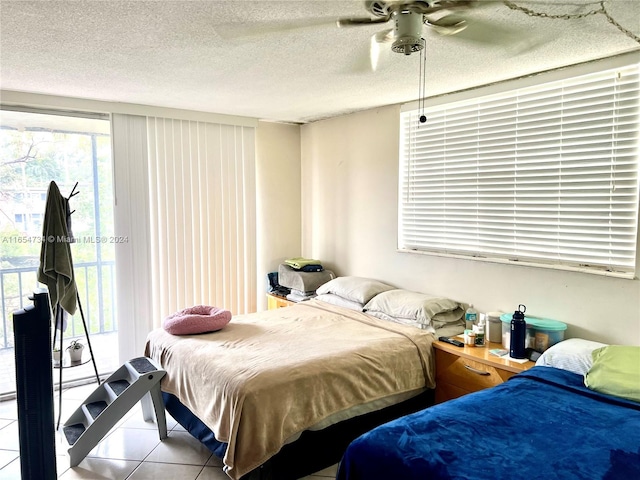 bedroom featuring a textured ceiling, ceiling fan, tile patterned floors, and multiple windows