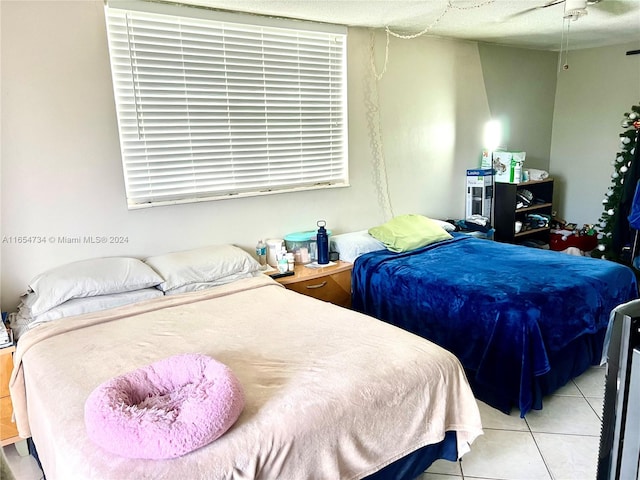 tiled bedroom featuring ceiling fan