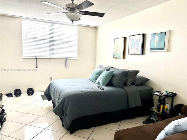 tiled bedroom featuring a textured ceiling and ceiling fan