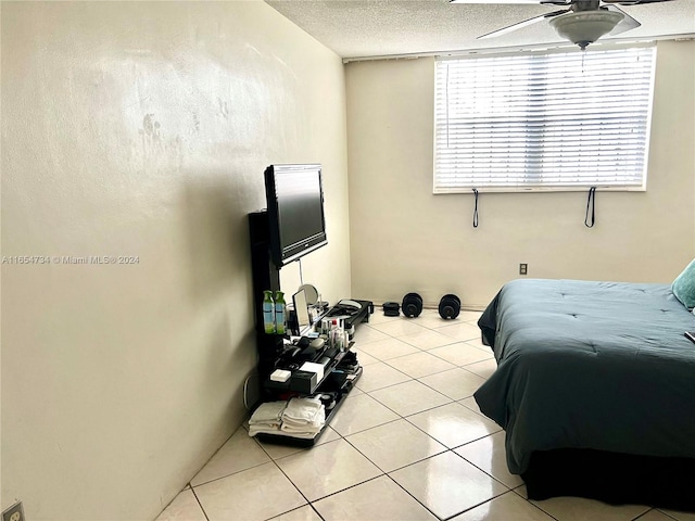 bedroom with ceiling fan, a textured ceiling, and light tile patterned flooring