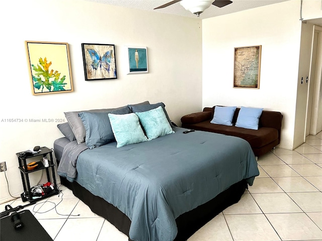 bedroom featuring a textured ceiling, light tile patterned floors, and ceiling fan