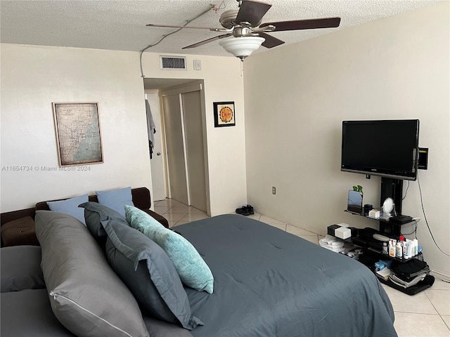 tiled bedroom featuring ceiling fan and a textured ceiling