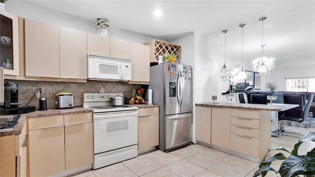 kitchen with an inviting chandelier, white appliances, backsplash, hanging light fixtures, and kitchen peninsula