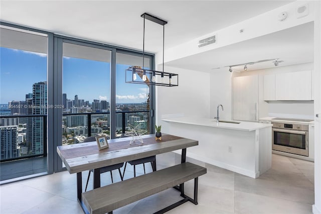 dining area featuring expansive windows, sink, and a notable chandelier