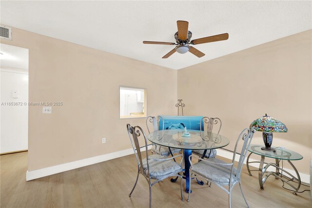 dining room with ceiling fan and hardwood / wood-style flooring