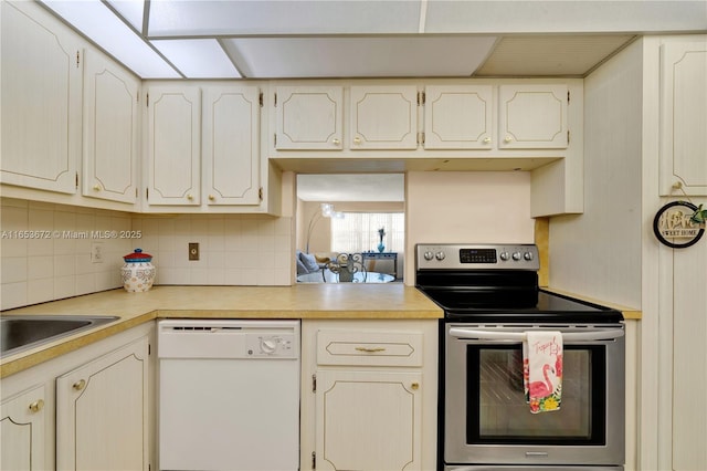 1516 S Lakeside Dr Unit 112, Lake Worth, FL 33460 - kitchen with white dishwasher, stainless steel electric stove, backsplash, light countertops, and white cabinetry
