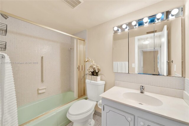 full bathroom featuring vanity, tiled shower / bath combo, toilet, and tile patterned flooring