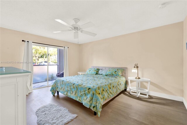 bedroom with access to outside, hardwood / wood-style floors, and ceiling fan