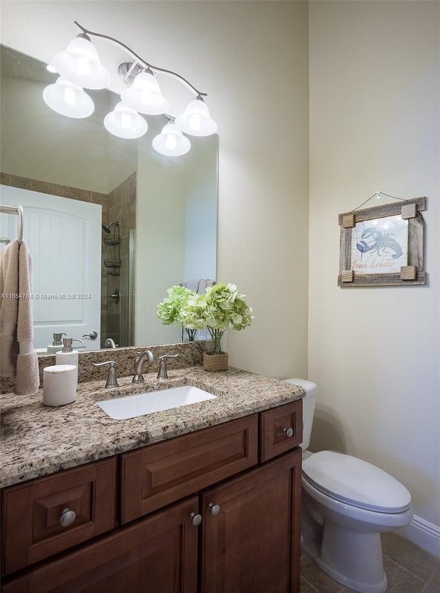 bathroom featuring tiled shower, tile patterned flooring, toilet, and vanity