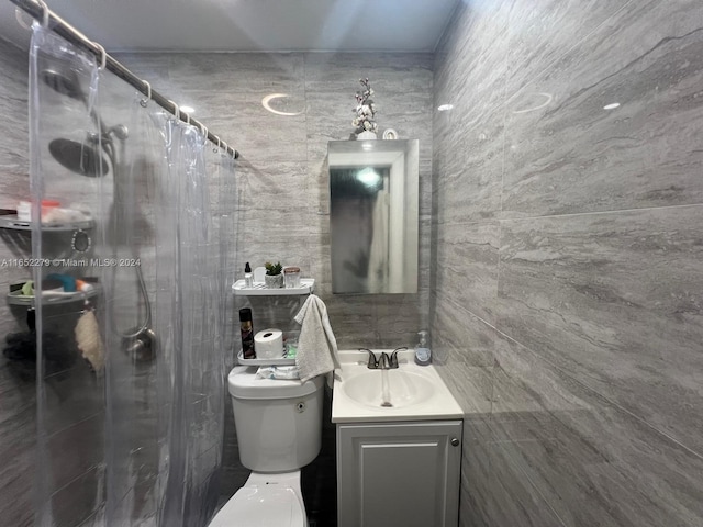 bathroom with tile walls, a shower with curtain, toilet, and vanity