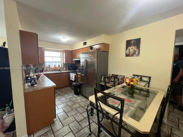 kitchen with appliances with stainless steel finishes, backsplash, and sink