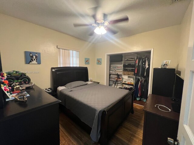 bedroom with a closet, ceiling fan, dark hardwood / wood-style flooring, and a textured ceiling