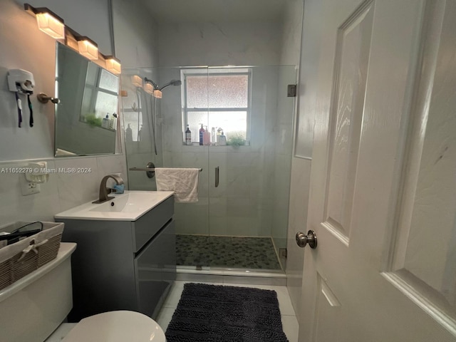 bathroom with toilet, tile patterned flooring, vanity, backsplash, and a shower with shower door