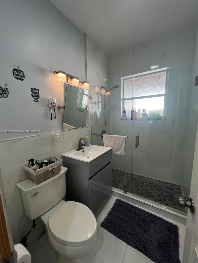 bathroom featuring tile patterned floors, walk in shower, toilet, tile walls, and vanity