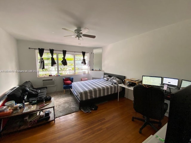 bedroom featuring a wall mounted AC, ceiling fan, and wood-type flooring