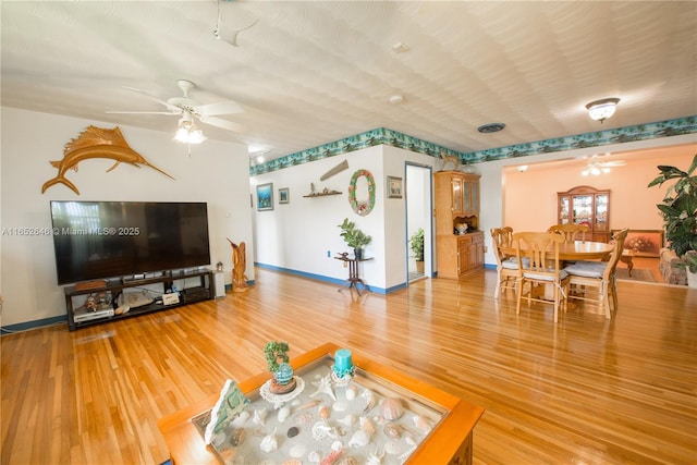 living room featuring hardwood / wood-style floors and ceiling fan