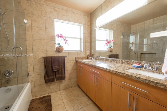 bathroom featuring vanity, combined bath / shower with glass door, tile walls, and tile patterned floors