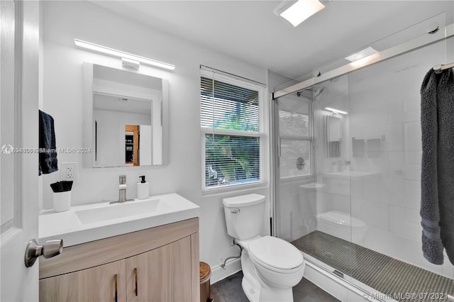 bathroom with an enclosed shower, toilet, and vanity