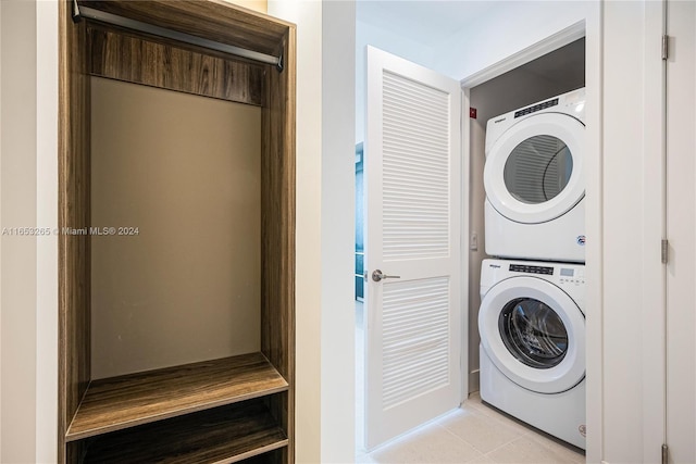 laundry area with light tile patterned floors and stacked washer and clothes dryer