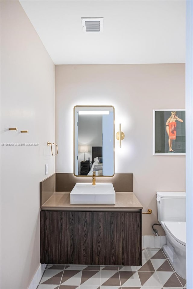 bathroom with vanity, toilet, and tile patterned flooring