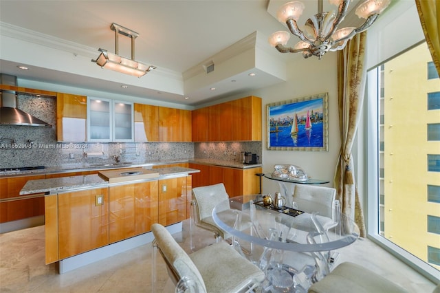 kitchen featuring ornamental molding, wall chimney exhaust hood, and a center island