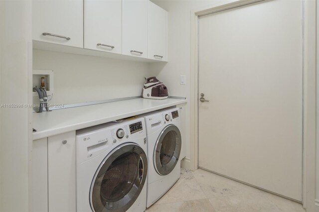 laundry area with light tile patterned floors, cabinets, and washing machine and clothes dryer