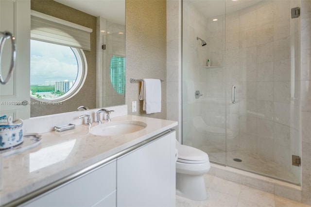 bathroom with tile patterned flooring, vanity, toilet, and a shower with shower door