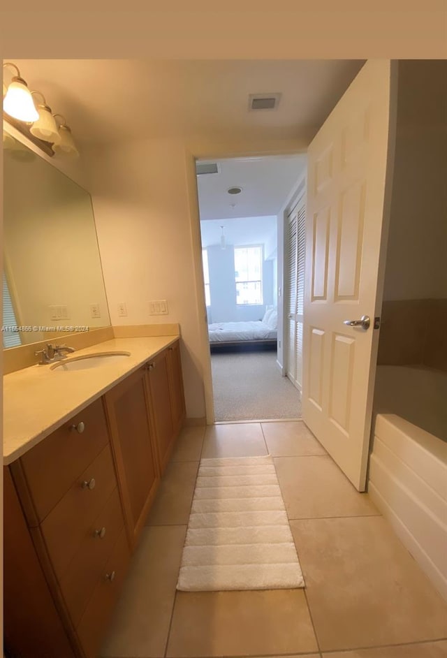 bathroom featuring vanity, a tub, and tile patterned floors