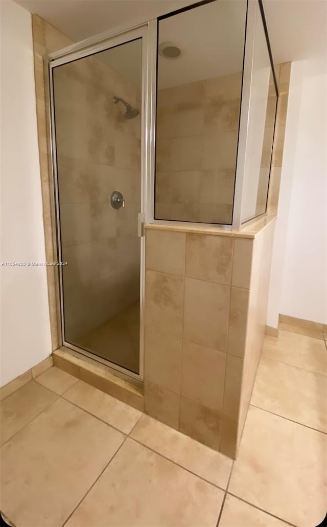 bathroom featuring a shower with shower door and tile patterned flooring