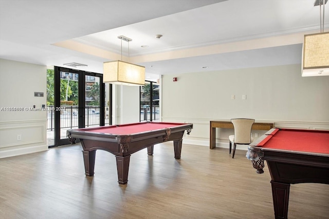 recreation room with french doors, a tray ceiling, hardwood / wood-style flooring, and billiards