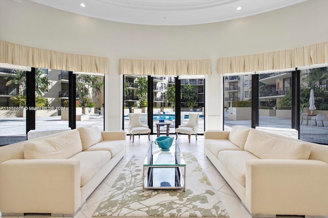 living room with ornamental molding, light tile patterned floors, and a high ceiling