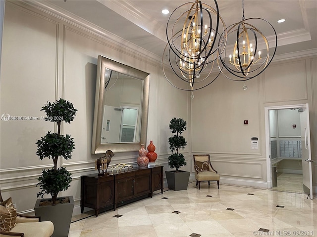 interior space with crown molding, a tray ceiling, and a chandelier